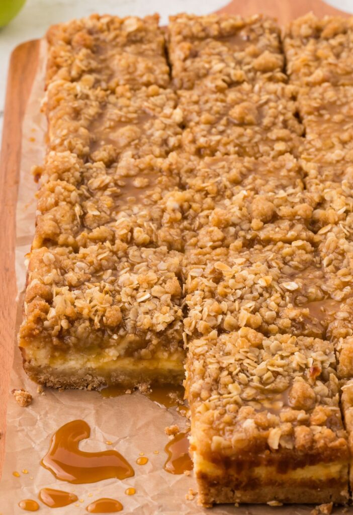 Cheesecake bars on a wooden cutting board. 