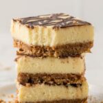 Stack of three Nutella cheesecake bars on a white plate