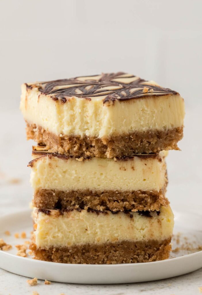 Stack of three Nutella cheesecake bars on a white plate