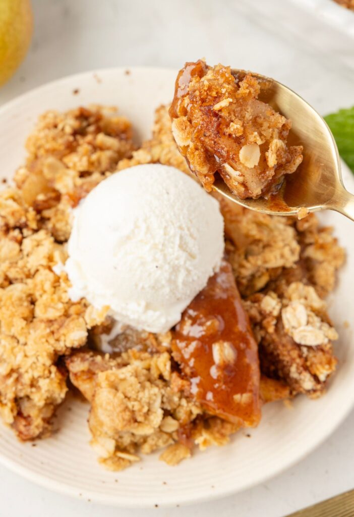 A spoon with some of the fruit crisp on it