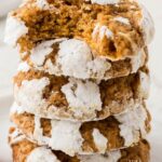 Stack of pumpkin cookies with crinkle powdered sugar