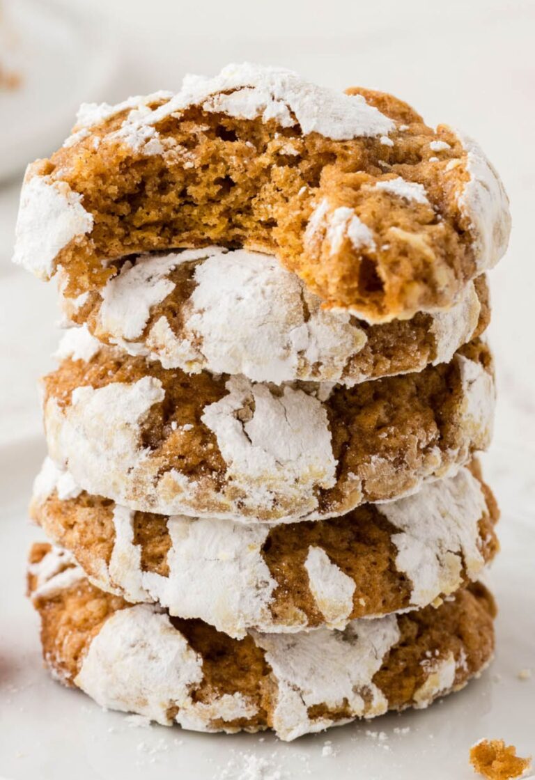 Stack of pumpkin cookies with crinkle powdered sugar