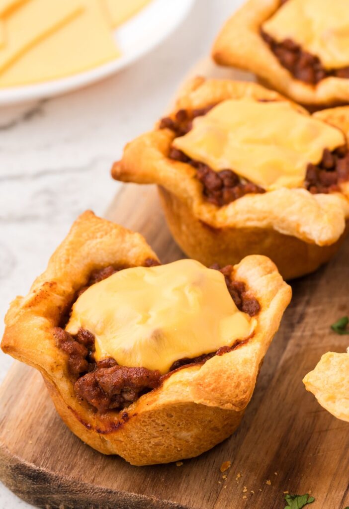 Baked sloppy Joe cups on a wooden cutting board