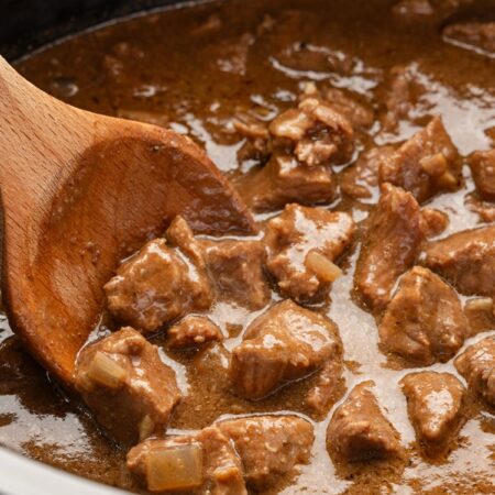 Inside of the slow cooker with the tender beef tips and brown gravy sauce.
