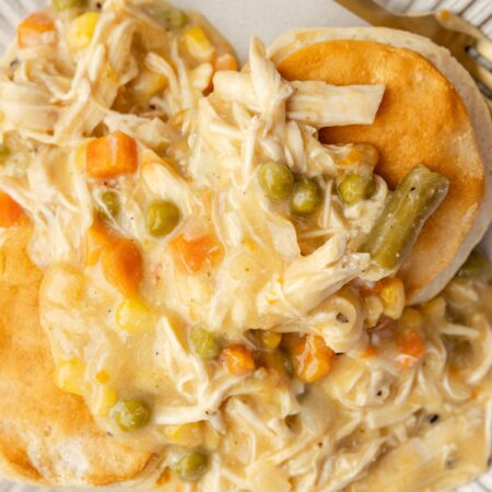 A serving of chicken pot pie over top biscuits