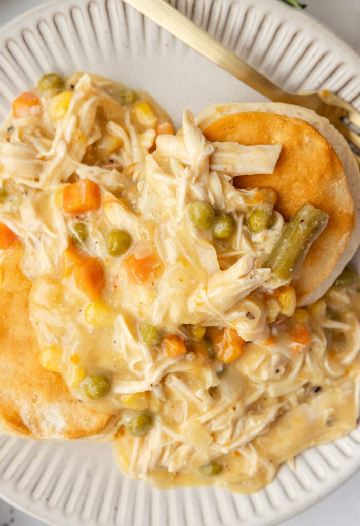 A serving of chicken pot pie over top biscuits
