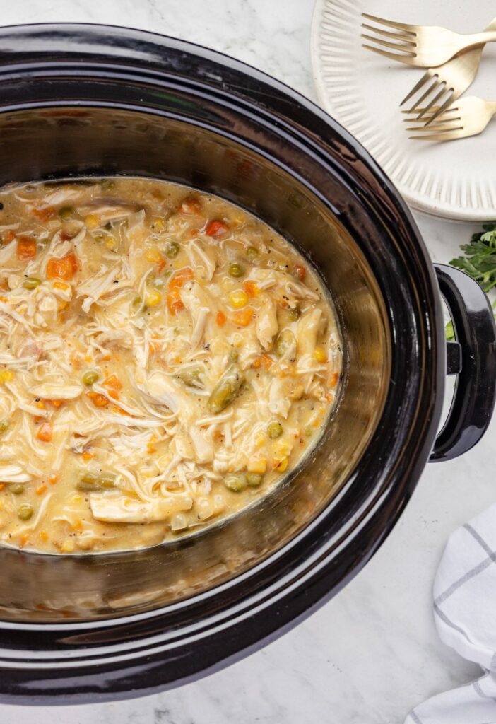 A slow cooker with chicken pot pie inside of it