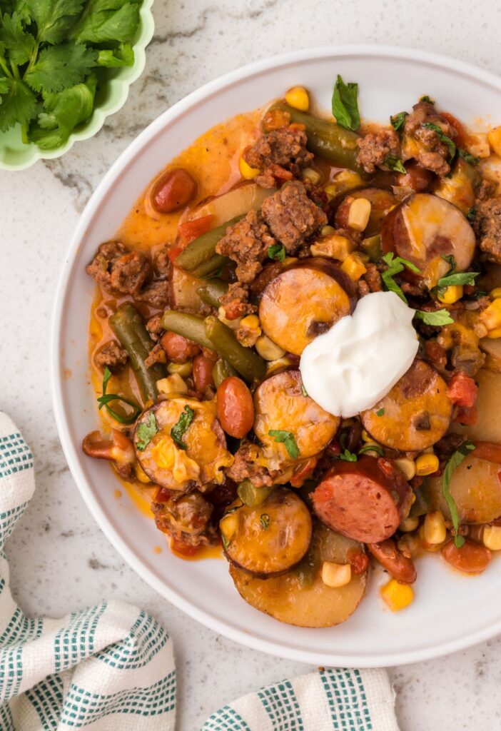 A serving plate of the cowboy casserole with sour cream on top