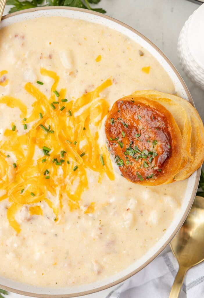 A bowl of soup with a biscuit in it