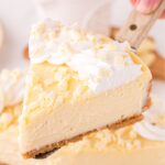 A serving spatula with a slice of white chocolate cheesecake on it