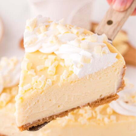 A serving spatula with a slice of white chocolate cheesecake on it