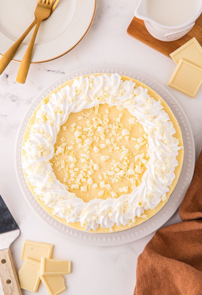 Whole cheesecake with whipped cream and white chocolate chips on top