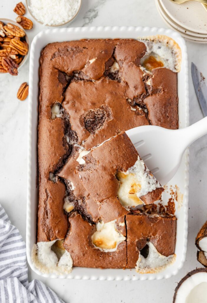 Pan of cake with a serving spatula with a slice on it. 