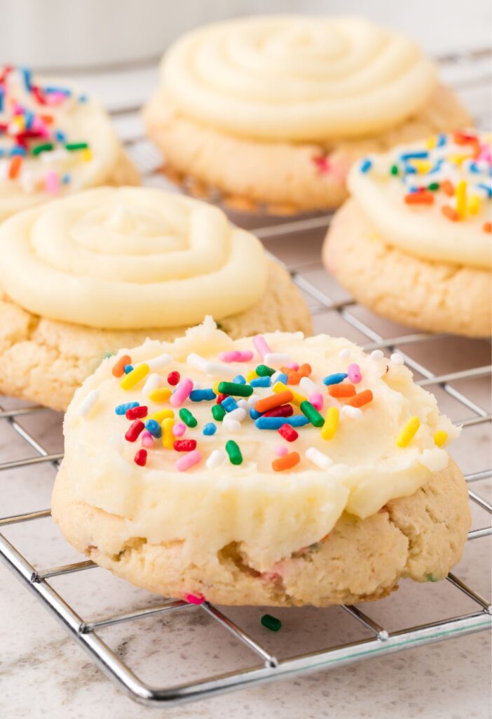 One cookie with frosting on the edge of the cooling rack