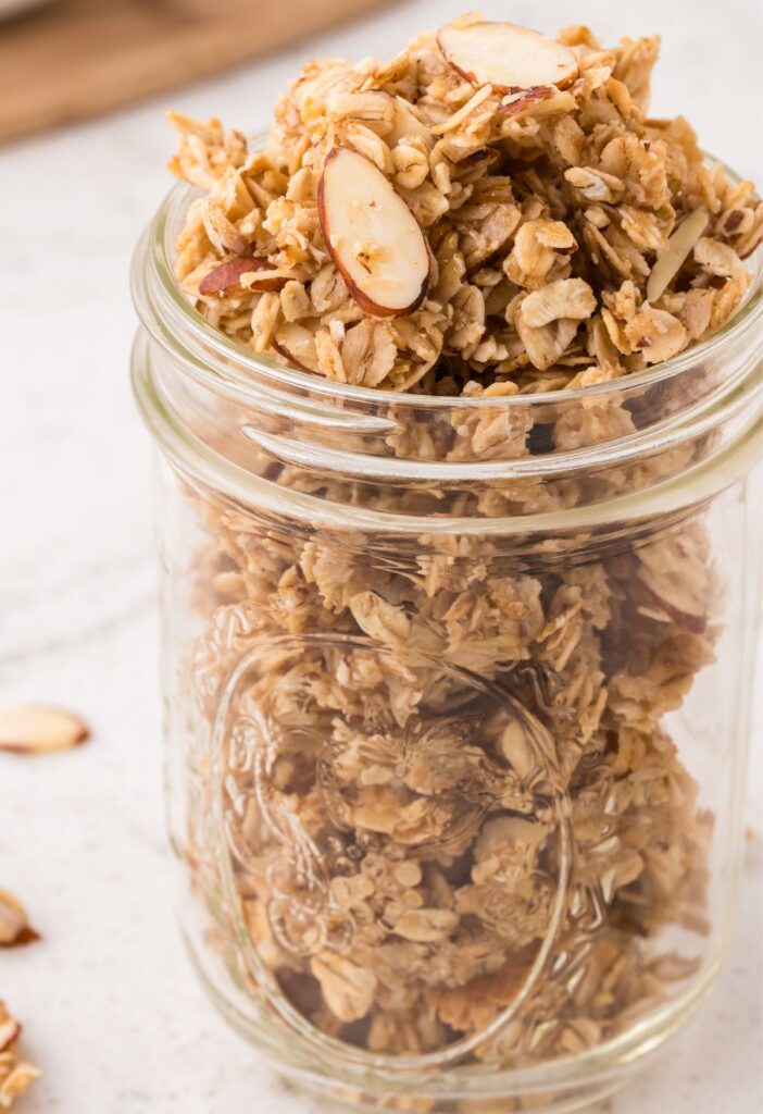 A clear glass jar of granola