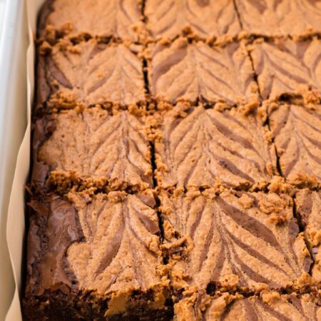 side view of the pan of baked brownies with a peanut butter swirl on top.