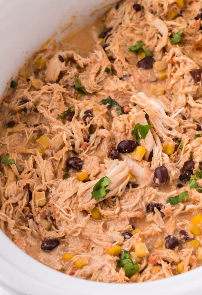 Inside of the slow cooker with the shredded fiesta chicken 