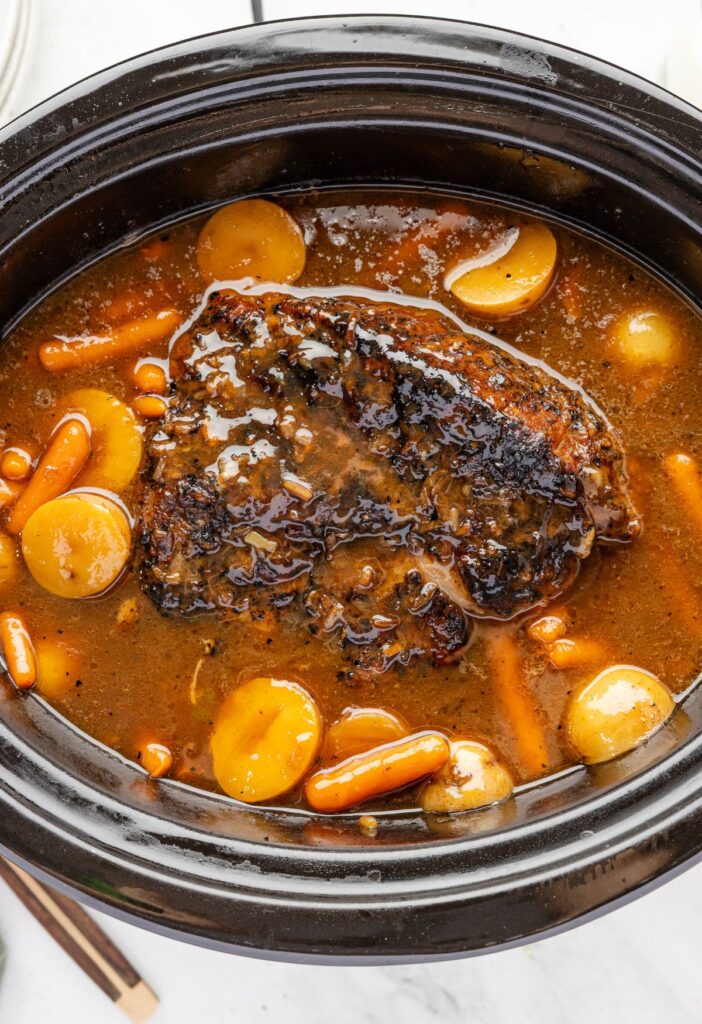 Inside of the slow cooker with the pork roast