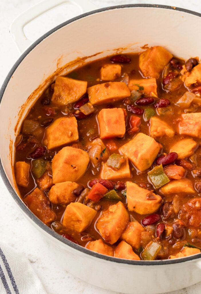 Side view of the inside of the soup pot with chunky sweet potato chili in it. 