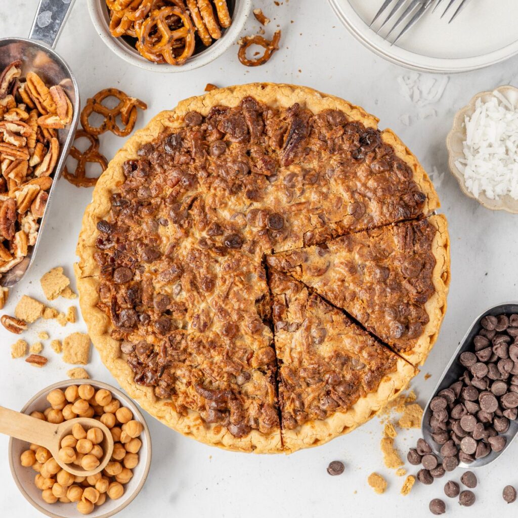 Hero picture of the baked pie cut into slices, with bowls of ingredients around it. 