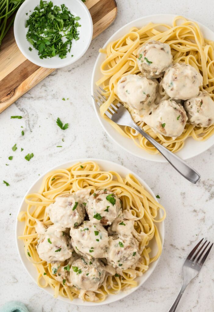 Serving plates of the Alfredo meatballs over pasta. 