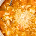Top view of the soup inside a white bowl with a spoon in it.