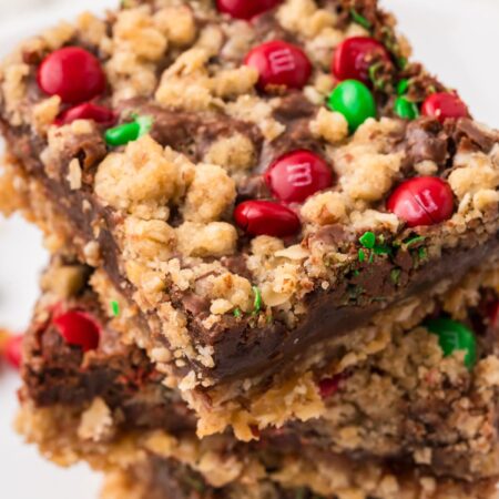 Stack of christmas cookie bars with red and green candies.