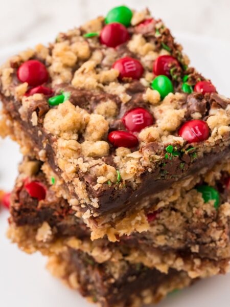 Stack of christmas cookie bars with red and green candies.