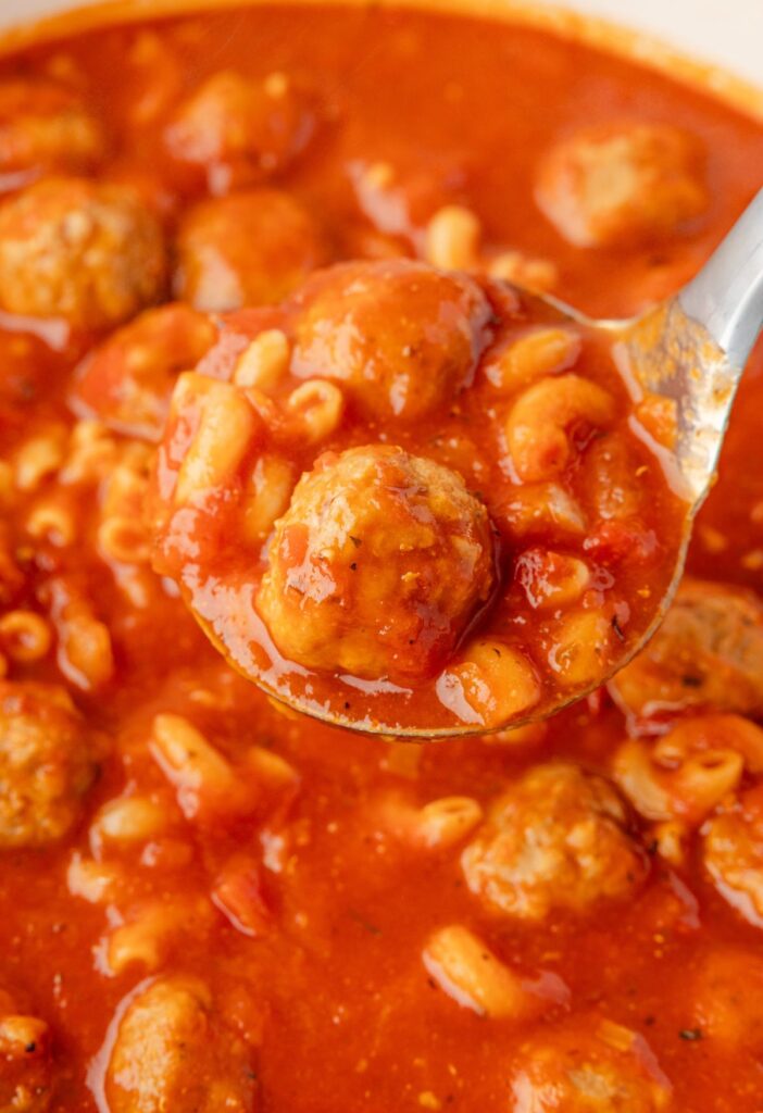 A soup ladle inside the pot of soup