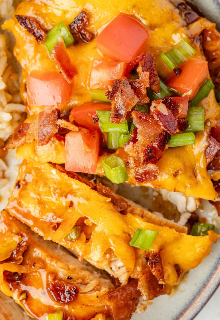 Chicken breast with bbq sauce, cheese, and bacon cut into slices.