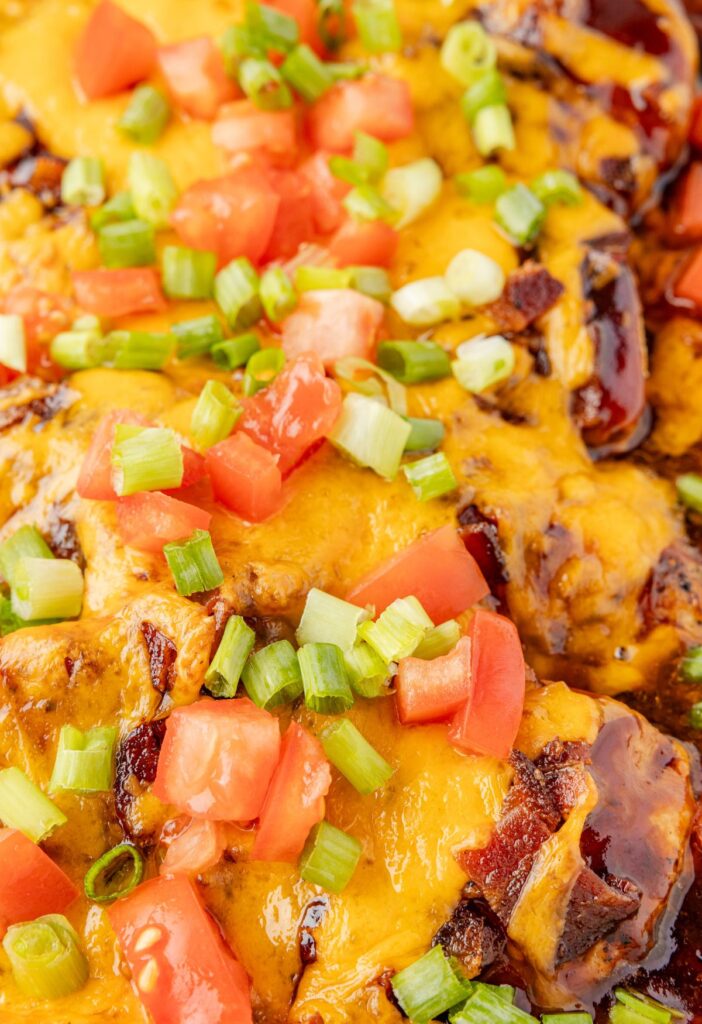Pan of the baked Monterey chicken breasts up close to see the toppings and bbq sauce. 
