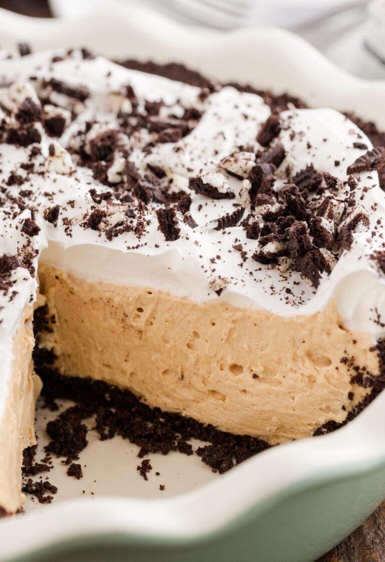 Pie plate with the peanut butter pie in it and Oreo crust, a piece cut out so you can see the center.