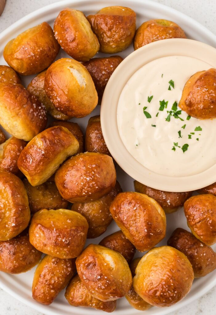 Pretzel bites on a plate with a bowl of dip.