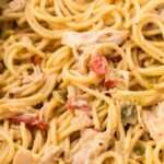 Close up of the creamy cheesy chicken spaghetti inside a white slow cooker.