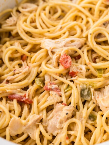 Close up of the creamy cheesy chicken spaghetti inside a white slow cooker.