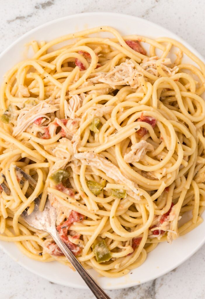 White serving plate of the chicken spaghetti with a fork