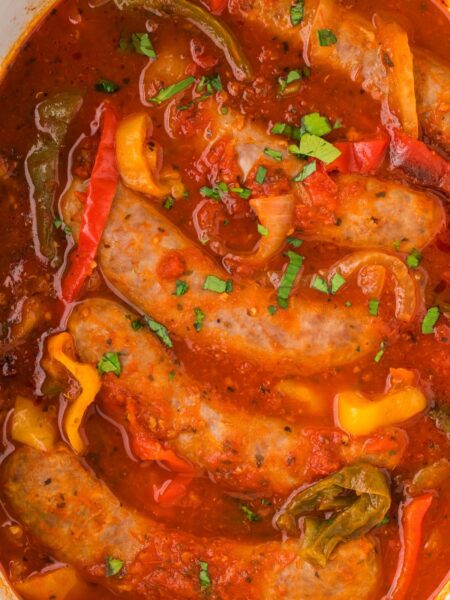 Top close up view of the sausages and peppers in marinara sauce.