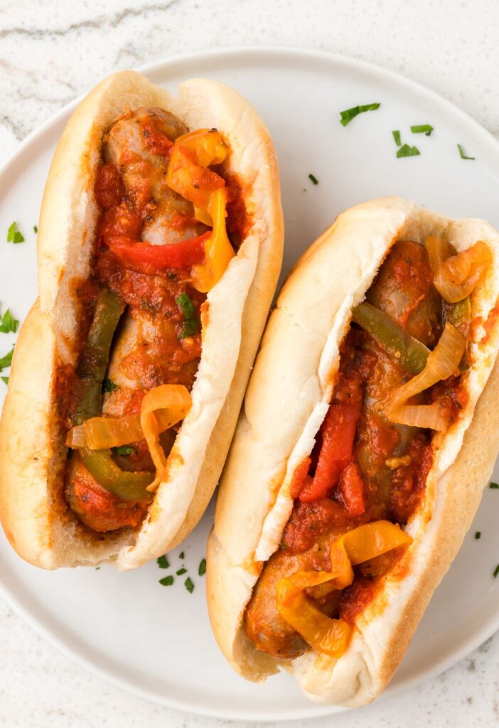 Sausages and peppers inside hoagies rolls for a sandwich. 