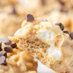 Two cookies with a bite taken out of one so you can see the marshmallows