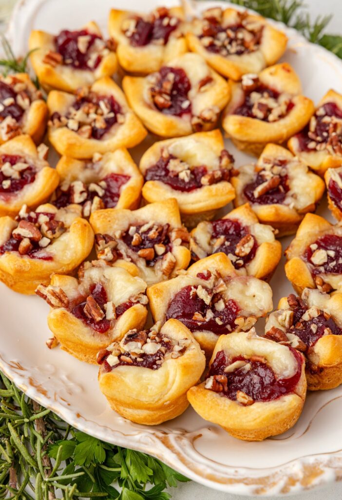 Side view of a platter of brie bites with cranberry sauce.