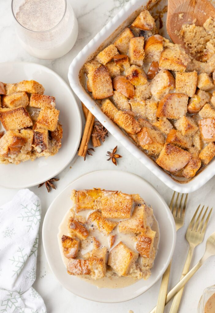 A serving of bread pudding with the baking dish of it next to it. 