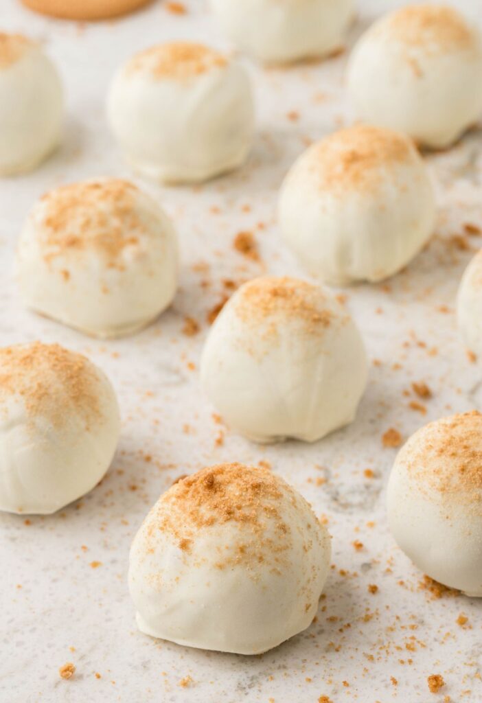 White table of truffles sprinkles with cookie crumbs.