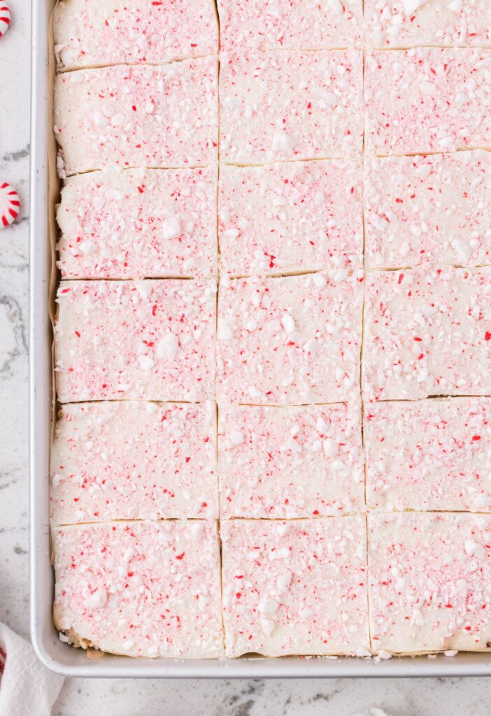 Top view of the pan of Krispie treats with white chocolate on top and candy canes. 