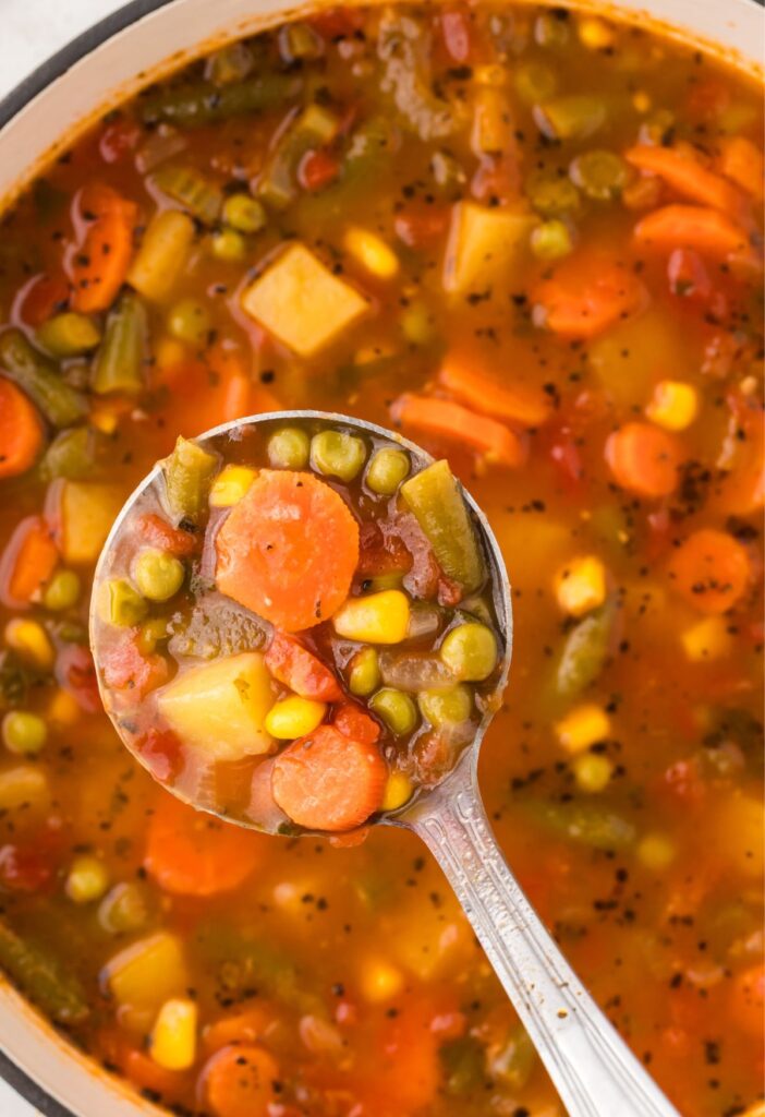 A soup ladle with soup in it