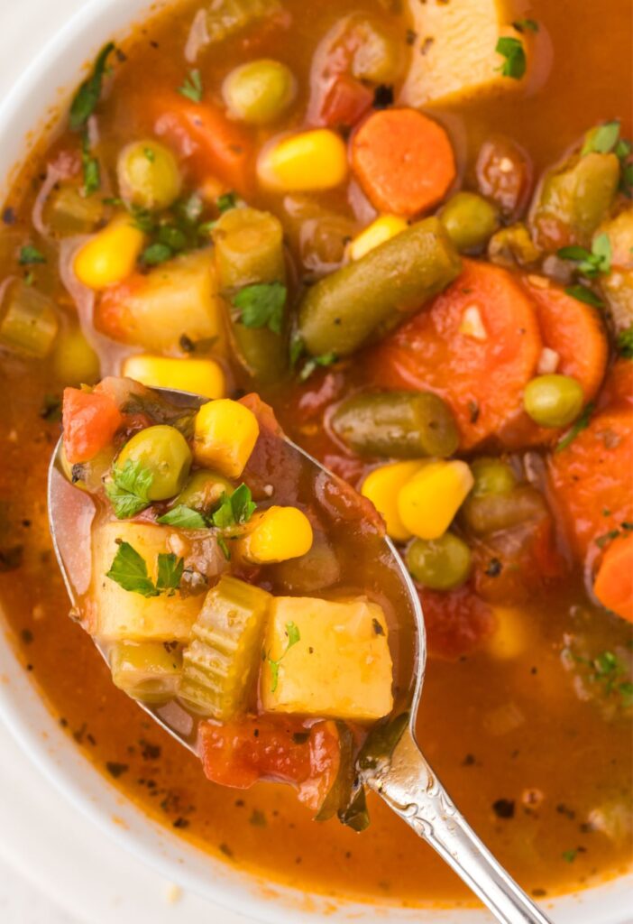 A top view of the vegetable soup with a spoon in it.