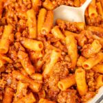 Beefaroni in a skillet with a serving spoon in it.