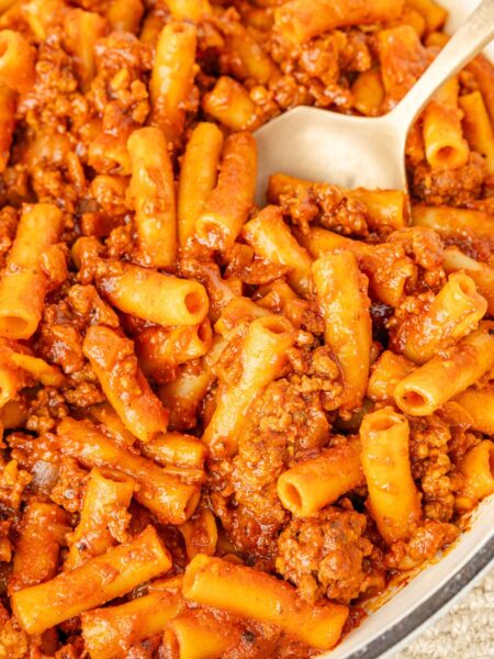 Beefaroni in a skillet with a serving spoon in it.
