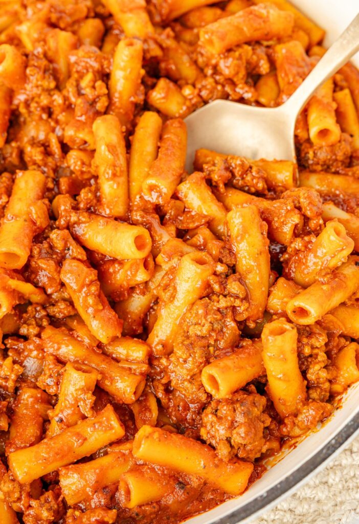 Beefaroni in a skillet with a serving spoon in it.
