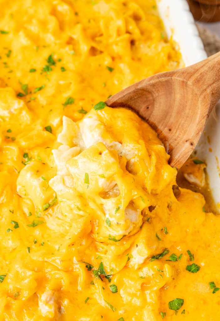 A wooden spoon inside the cheesy casserole