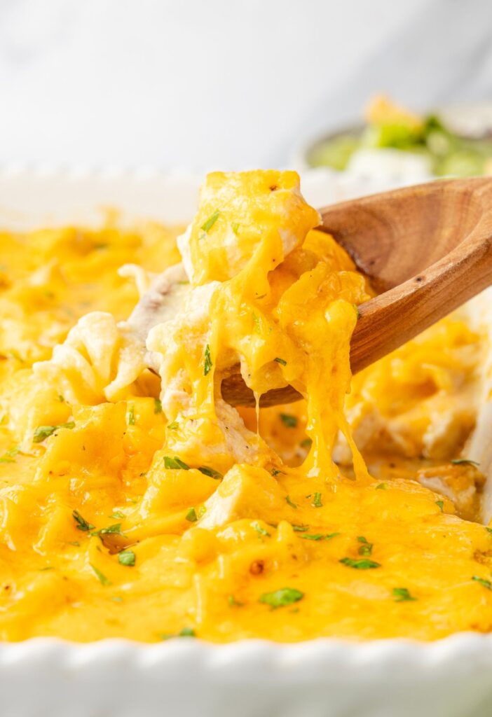 A wooden spoon with some casserole on it.